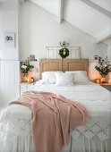 Doppelbett mit weißer Spitzendecke, Kopfteil aus alten Türblättern in weihnachtlich dekoriertem Schlafzimmer