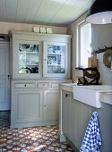 Country kitchen with farmhouse sink and antique floor tiles