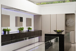 Custom-made designer kitchen with glass elements, high-gloss surfaces and indirect lighting