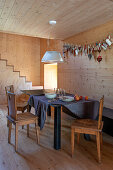 Dining room with light-coloured wooden walls, garland of fabric hearts