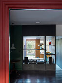 Blick in offenen Wohnraum mit dunkelgrünen Wänden und zentralem Raumteiler