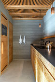 Moderne Küche mit Holzelementen und Betonwänden