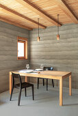 Minimalist dining room with exposed concrete walls and wooden accents