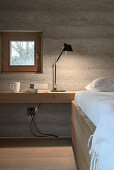 Minimalistisches Schlafzimmer mit Betonwand und integriertem Schreibtisch