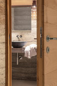 Blick auf modernes Badezimmer durch geöffnete Holztür