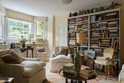 Helles Wohnzimmer mit maßgefertigtem Bücherregal und Howard-Sessel aus cremefarbenem Leinen