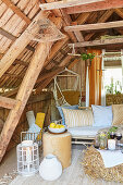Gemütliche Leseecke im Landhausstil mit Hängesessel und rustikalen Holzbalken