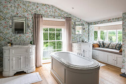 Country-style bathroom with floral wallpaper and freestanding bathtub