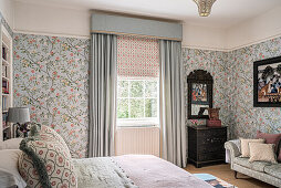 Schlafzimmer mit floralem Tapetenmuster und Vintage-Möbeln