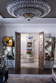 View through open double doors to a chinoiserie mirror and Regency armchair
