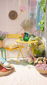 Farbenfroher Balkon mit gelbem Klapptisch, Stuhl und Sommerblumen