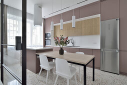 Modern kitchen with dining table and fresh flowers in Warsaw flat