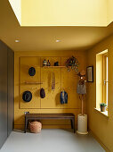 Side entrance with bench and storage wall in yellow