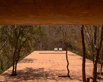 Terracotta-tiled terrace with sun loungers under a concrete ceiling, Mexico