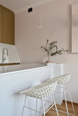 Modern kitchenette with bar stools and pendant lights in studio flat