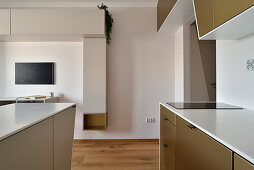Minimalist kitchen with oak parquet flooring and workstation in the background