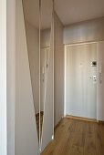 Entrance area with mirrored wardrobe and wooden floor in a studio