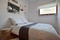Schlafzimmer mit maritimer Dekoration und Fotokunst an der Wand