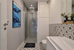 Modern bathroom with patterned tiles and mural