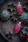 Old biscuit tins and red cone Christmas decorations on a baking tray