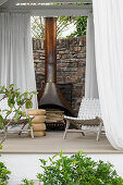 Terrace with fireplace, white curtains and woven chairs