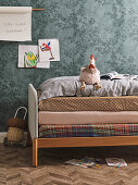 Cot with three mattresses and toy chicken on the bed