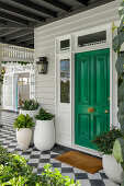 Green front door, plant pots and chequerboard tiles on the veranda