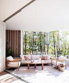 Modern lounge area on a covered terrace with wooden furniture