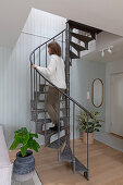 Metal spiral staircase with indoor plants in a modern living area