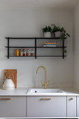 Modern kitchen with golden tap and open shelves