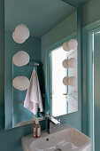 Modern bathroom with blue walls and globe lights