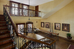 Staircase with ornate banisters and large chandelier