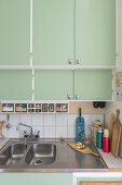 1940s-style kitchen with mint green cupboard doors