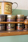 Metal storage tins on a wooden kitchen shelf