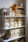 Storage tins and retro radio on a vintage-style kitchen shelf