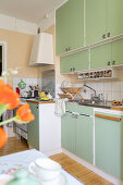 1940s-style kitchen with green fitted cupboards