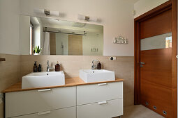 Bathroom with double washbasin and wooden door