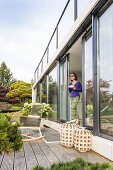 woman at the terrace door with a cup, coodo modern way of living, modern architecture in Hamburg, north Germany, Germany