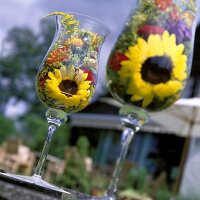 Sommerblumen in Gläsern als Tischdeko im Freien