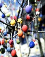Brightly painted Easter eggs on branches in open air