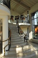 Treppenaufgang aus Marmor mit ornamentalem Metallgeländer