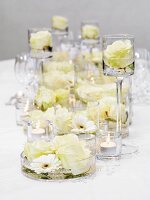 Festliche Tischdeko mit weissen Blumen und Teelichtern