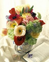 Blumenstrauss in einer Vase, aufgeschlagenes Buch