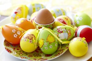 Decorated plastic Easter eggs and a boiled egg in an egg cup