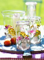 Preserving jars used as candle lanterns and decorated with flowers and water