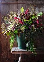 Autumnal bouquet in vase on wooden stool