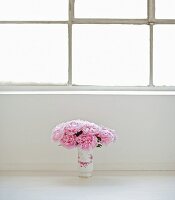 Bouquet of peonies in vase on floor