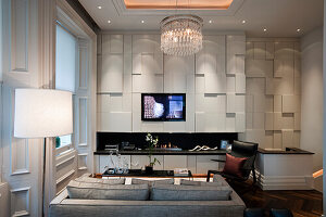 Modern living room with geometric wall panelling and chandelier