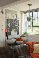 Living room with brown leather sofa and various works of art