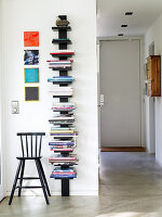 Wandmontiertes Bücherregal mit Stuhl in minimalistischem Flur
